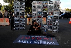Activist Suciwati, widow of human rights activist Munir, embraces Maria Catarina Sumarsih, mother of Benardinus Realino Norma Irawan, or Wawan, a university student who was killed during the Semanggi Tragedy. Behind them is a photo installation made for the 10th commemoration of the Kamisan silent protest on Jan. 19. JP/ Seto Wardhana