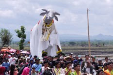 People parade the statue of Kebo Ketan around Sekarputih village last month. Kebo Ketan was 2.5 meters high, 4.5 meters long and made from sticky rice. Additionally, the plastic head was made by renowned artist Heri Dono. JP/Magnus Hendratmo