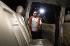 Corruption suspect Basuki Hariman walks to a car after being questioned by the Corruption Eradication Commission (KPK) on Jan. 27. Basuki has reportedly confessed to giving US$20,000 and S$200,000 to an aide of Constitutional Court justice Patrialis Akbar, identified as Kamaludin. 