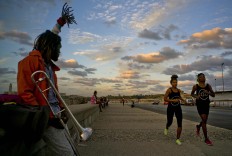 In this Jan. 30, 2017 photo, boxers Idamerys Moreno, second right, and Legnis Cala, right, run along Havana's Malecon, in Cuba. Moreno and Cala are part of a group of up-and-coming female boxers on the island who want government support to form Cuba's first female boxing team and help dispel a decades-old belief once summed up by a former top coach: "Cuban women are meant to show the beauty of their face, not receive punches." AP/Ramon Espinosa
