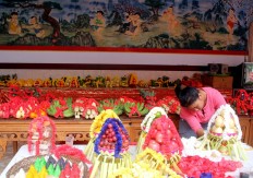 A woman decorates offerings comprising fruit and cakes at Darmayana Temple in Kuta, Bali, on Jan. 25. JP/ Zul Trio Anggono
