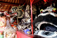 A man paints a dragon effigy at Griya Konco Temple in Tanah Kilap, Denpasar, Bali, on Jan. 22. JP/ Zul Trio Anggono