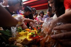 Congregation members of Poncowinatan Temple in Yogyakarta use the Javanese dish tumpeng during their prayers. Tumpeng, a cone of yellow rice with various sides, is used in the ritual to display the acculturation of Chinese and Javanese cultures. JP/Aditya Sagita