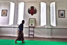 A palace servant walks while slightly bowing as a gesture of respect when passing through the Yogyakarta Kraton. JP/ Aditya Sagita