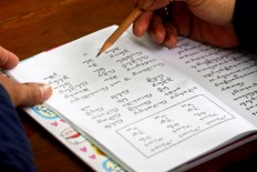 A student uses a pencil to aid him in reading Javanese script. JP/ Aditya Sagita
