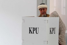 Mohamad Ridwan is helped by his wife Khodijah when voting at the TPS 39 polling station in Citeureup subdistrict, Cimahi city, West Java. Voters with special needs can request assistance from family members when voting. JP/Arya Dipa