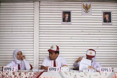 Polling station officials at TPS45 in Kebon Pala, East Jakarta, wear elementary school uniforms as a gimmick to attract voters. Almost 7 million eligible voters cast their votes in Jakarta. JP/Dhoni Setiawan