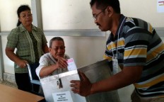A leprosy patient is assisted by a nurse at Alverno Hospital in Singkawang, West Kalimantan, while he votes. JP/ Severius Endi