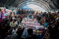 Relatives of landslide victims watch over their corpses in Songan village on Monday, February 13, 2017. JP/ Anggara Mahendra