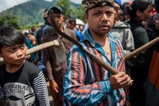 Men carry tools to clear earth in Songan village on Monday, February 13, 2017. JP/ Anggara Mahendra
