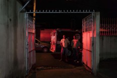 In this Feb. 5, 2017 photo, residents watch police inspect a home where a woman was shot to death in Manaus, Brazil. "Citizens are the ones who are truly jailed these days," said Claudio Lamachia, head of Brazil's bar association. "Members of the crime gangs are dictating the rules and stopping people from leaving their homes." AP Photo/Felipe Dana