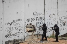 In this Jan. 21, 2017 file photo, Special Operations Battalion Police officers enter the Alcacuz prison amid tension between rival gangs in Nisia Floresta, near Natal, Brazil. Brazil incarcerates more than 620,000 people in a system that has space for a little over 370,000, according to a 2014 Ministry of Justice report. Forty percent of detainees are merely awaiting trial. AP Photo/Felipe Dana, File