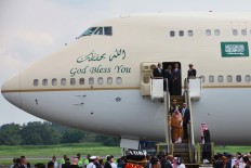 King Salman bin Abdulaziz Al Saud rides down the electric stairs to disembark from his plane after his arrival at Halim Perdanakusuma Airport in Jakarta, on Wednesday. JP/Dhoni Setiawan