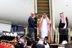 King Salman (center) adjusts his headscarf as he reaches the bottom of the stairs upon his arrival at Halim Perdanakusuma Airport. The Saudi king arrived in the world's largest Muslim-majority nation on Wednesday as a part of a month-long Asian tour aimed at boosting economic ties with the continent’s states. JP/Dhoni Setiawan