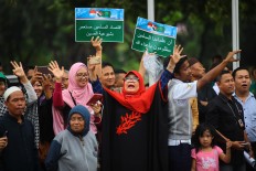 Carrying banners, Indonesian women greet King Salman bin Abdulaziz Al Saud upon his arrival at Halim Perdanakusuma Airport in East Jakarta on Wednesday. JP/Dhoni Setiawan