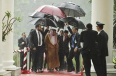 King Salman (second left) and Indonesian President Joko “Jokowi” Widodo (center) walk under umbrellas during heavy rain at the Presidential Palace in Bogor, West Java, on March 1. Salman arrived in the world's largest Muslim-majority nation on Wednesday as a part of a multi-nation tour aimed at boosting economic ties with Asia. AP/Pool/Achmad Ibrahim