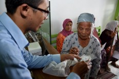 A medical staff member gives an explanation about the rules for drugs and drinking to a patient during the free health program in the Indonesia Medika Clinic, Malang, East Java, on Tuesday (21/2). JP/ Aman Rochman