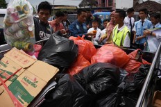 A staff member weighs the trash from residents, during the healthcare program in Indonesia Medika Malang, East Java, on Tuesday (21/2). The clinic’s healthcare program is a collaborative effort between BPJS Kesehatan, the Malang Environment Agency, students and residents. JP/Aman Rochman
