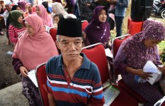 Sixty-five-year-old Supali sits with others, waiting for his turn to obtain free healthcare services. Using some recyclable trash as payment is being done for the first time in Indonesia. JP/ Aman Rochman