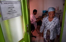 A resident walks out after getting treatment in the Indonesia Medika Clinic, Malang, East Java, on Tuesday (21/2). JP/ Aman Rochman