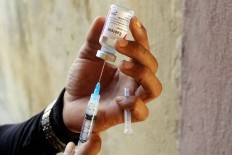 A man fills a syringe with a rabies vaccine for dogs and cats to prevent the spread of the virus. JP/ Zul Trio Anggono
