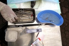 A veterinarian sterilizes a cat during a free rabies vaccination and neutering program at Lumintang Field, Denpasar, on Nov. 24, 2016. JP/ Zul Trio Anggono