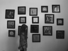 A visitor walks past pictures of musicians in one of Lokananta's rooms. JP/Ganug Nugroho Adi