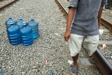Pilling up: Pio stocks his bottles in the space between two railway tracks while waiting for a train to pass. JP/ Jerry Adiguna