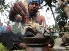 The village shaman lights incense before the procession begins. JP/Ganug Nugroho Adi

