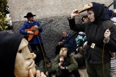 In this April 1, 2017 picture revelers from San Pedro Bernardo village wearing the traditional 'Machurrero' mask and outfit rest after a parade during a gathering of different villages' carnival masks and characters in the small village of Casavieja, Spain, Monday, April 3, 2017. AP /Daniel Ochoa de Olza