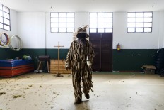 In this April 1, 2017 picture a man dressed as a 'Trapajon' and representing a natural entity walks in the village's gym used as a changing room after a traditional Spanish mask gathering in the small village of Casavieja, Spain, Monday, April 3, 2017. These festivals, held across central and northwestern Spain, most often coincide with festivities celebrating the advent of spring, mixing Carnival and bizarre pagan-like rituals with mock battles between good and evil. AP /Daniel Ochoa de Olza