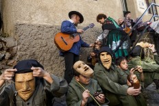 In this April 1, 2017 picture revelers from San Pedro Bernardo village wearing the traditional 'Machurrero' mask and outfit rest and eat after a parade during a gathering of different villages' carnival masks and characters in the small village of Casavieja, Spain, Monday, April 3, 2017. These festivals, held across central and northwestern Spain, most often coincide with festivities celebrating the advent of spring, mixing Carnival and bizarre pagan-like rituals with mock battles between good and evil. AP /Daniel Ochoa de Olza