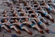 Already painted Jesus statues are ready to be put on crosses.  JP/Magnus Koeshendratmo