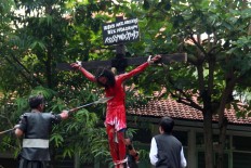 Congregants of Santa Theresa Church in Bojongsari, Semarang, Central Java, watch a performance depicting the crucifixion of Jesus Christ [portrayed by Yohannes Dendi] on Good Friday. JP/Suherdjoko