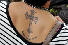 A congregant displays a tattoo of a cross on her back at Yohanes Rasul church, Wonogiri, Central Java on Friday April 14.  JP/Magnus Hendratmo