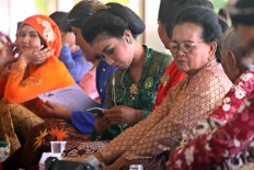 A contestant listens to macapat using earphones while waiting for her turn. JP/Aditya Sagita