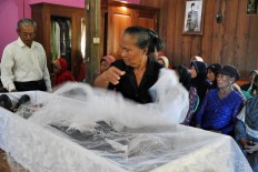A mourner looks at Mbah Jo Gotho&rsquo;s remains for the last time before the burial. JP/Magnus Hendratmo