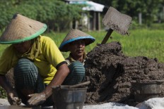 A man and his wife work together making bricks in Trowulan, Mojokerto regency, East Java. The man’s role is to mix the clay into a dough with husks, bran and sand while his wife molds the bricks. JP/Sigit Pamungkas