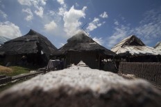 Three huts are used by brick makers to protect the bricks from rain during the firing process.  JP/Sigit Pamungkas