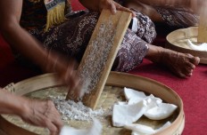 A royal servant grates coconut to be used as an ingredient to make apem at the Yogyakarta palace on July 6, 2013. JP/Tarko Sudiarno