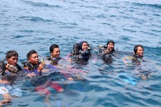 Divers pose after the planting stemmed coral reefs in Karimunjawa waters, Central Java. JP/Suherdjoko