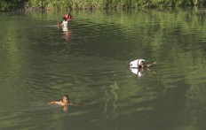 Bravery: Children in Sumba, East Nusa Tenggara, risk their lives every day by crossing a crocodile infested river to go to school. They are ussualy accompanied by an adult who carries their school supplies and uniforms in a dry bag. JP/ Tarko Sudiarno