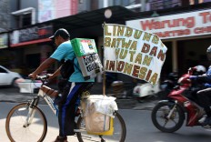 Samsudin rides a bicycle on his journey to tell stories about forests and animals to children in cities across Indonesia. JP/Aman Rochman