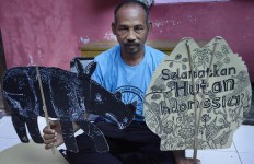Samsudin poses with cardboard cutouts after storytelling at the kindergarten on April 4. JP/Aman Rochman