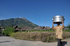 A villager walks across the road to join the Nyadran tradition at Cepogo, Boyolali regency, Central Java. JP/Ganug Nugroho Adi