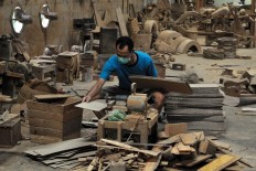 A worker cuts plywood in the workshop. Eko’s workshop has also produced a replica of big motorcycle made of teakwood waste. JP/Magnus Hendratmo