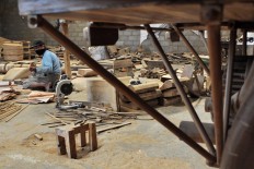 A man works on wooden parts at the workshop. JP/Magnus Hendratmo