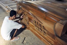 A worker installs a wheel before packing the replica and sending it to a buyer. JP/Magnus Hendratmo