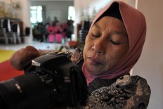 Rusidah checks the result of her photoshoot on her camera's LCD. JP/Magnus Hendratmo
