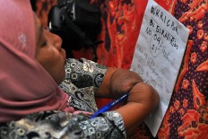 Rusidah writes the orders from her customers. JP/Magnus Hendratmo
